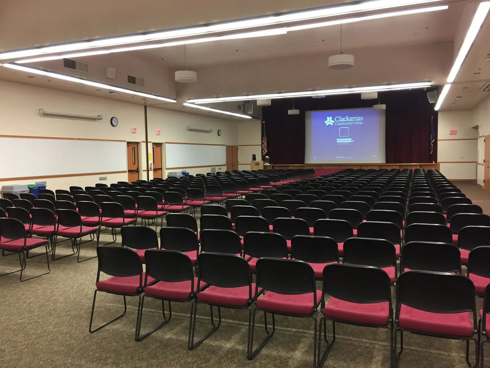 Neatly organized rows of chairs in front of a projector screen Gregory Forum on the Oregon City campus